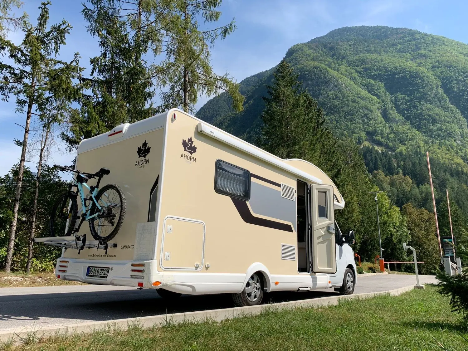 Wohnmobil mit Fahrrädern am Heck vor Bergkulisse